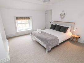 A bedroom with a bed and window at Canny Cottage in Belford