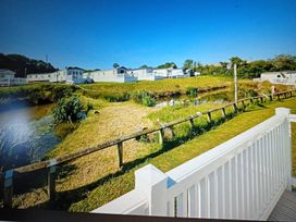 An outdoor area with grass and mobile homes at Hedley Wood Park-Duckpool8 Holsworthy
