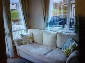 A sofa with pillows in a living room at Hedley Wood Park-Duckpool8 in Holsworthy