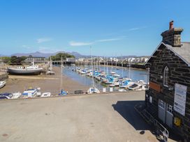 A view of boats at a marina with a building at Cnicht View in Porthmadog