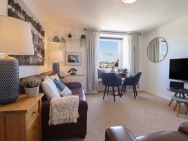 A living room with a sofa and dining area at Cnicht View in Porthmadog