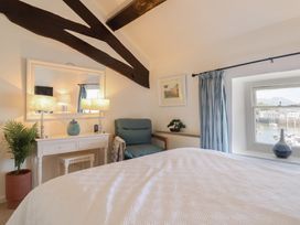 A bedroom with a bed, table, and window at Cnicht View Porthmadog