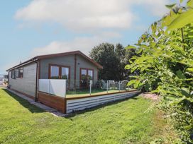 A house with a fenced area and grass at Excalabur 10 in Morfa Bychan
