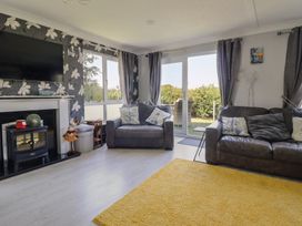 A living room with a television and sofa at Excalabur 10 Morfa Bychan