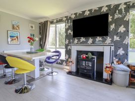 A dining room with a table and chairs at Excalabur 10 in Morfa Bychan