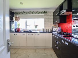 A kitchen with cabinets and appliances at Excalabur 10 in Morfa Bychan