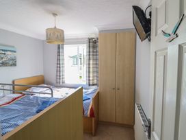 A bedroom with a bed and television at Excalabur 10 in Morfa Bychan