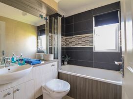 A bathroom with a bathtub, toilet, and sink at Excalabur 10 in Morfa Bychan