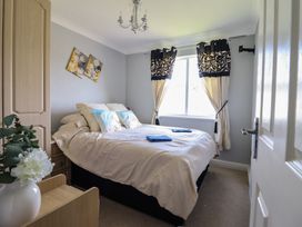 A bedroom with a bed and window at Excalabur 10 Morfa Bychan