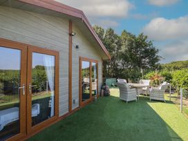 An outdoor area with a dining table and chairs at Excalabur 10 in Morfa Bychan