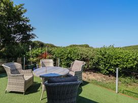 A garden with a table and chairs at Excalabur 10 Morfa Bychan