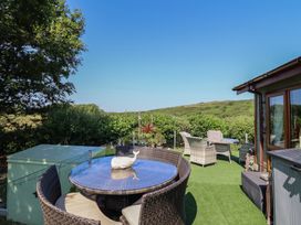 An outdoor seating area with a table and chairs at Excalabur 10 in Morfa Bychan