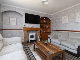 A living room with a fireplace and shelves at 31 Ffordd Y Maer Pwllheli