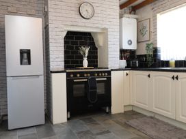 A kitchen with a refrigerator, oven and countertop at 31 Ffordd Y Maer in Pwllheli