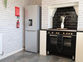 A kitchen with a refrigerator and oven at 31 Ffordd Y Maer in Pwllheli