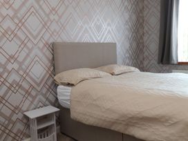 A bedroom with a bed and nightstand at 31 Ffordd Y Maer in Pwllheli