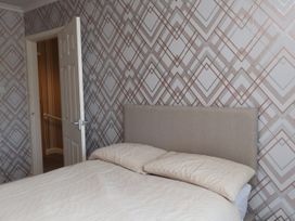 A bedroom with a bed and door at 31 Ffordd Y Maer in Pwllheli