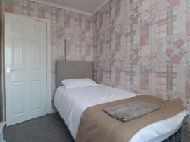 A bedroom with a bed and door at 31 Ffordd Y Maer in Pwllheli