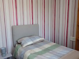 A bedroom with a bed and lamp at 31 Ffordd Y Maer in Pwllheli