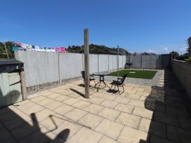 A garden with a table and chairs at 31 Ffordd Y Maer in Pwllheli