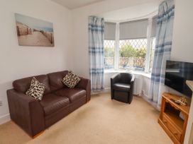 A living room with a sofa and television at 19 Dunstan View in Seahouses