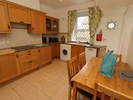 A kitchen with cabinets and appliances at 19 Dunstan View Seahouses
