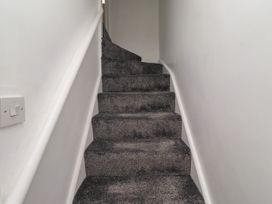 A staircase with carpet and a handrail at 19 Dunstan View Seahouses