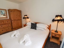 A bedroom with a bed and wardrobe at 19 Dunstan View in Seahouses