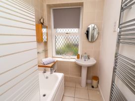 A bathroom with a bathtub and washbasin at 19 Dunstan View Seahouses