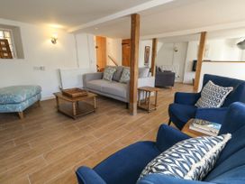 A living room with sofas, armchairs and a coffee table at Greenwich Cottage in Burton Bradstock