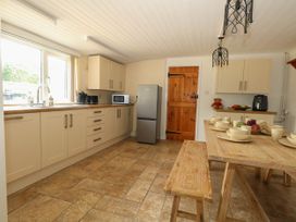A kitchen with a table set for meals at Greenwich Cottage in Burton Bradstock