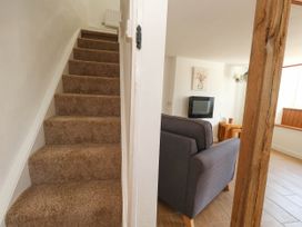 A living room with a sofa and television at Greenwich Cottage in Burton Bradstock