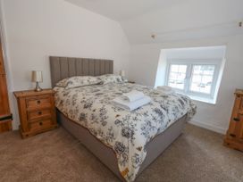 A bedroom with a bed and bedside tables at Greenwich Cottage in Burton Bradstock