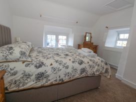 A bedroom with a bed, chest of drawers and mirror at Greenwich Cottage in Burton Bradstock