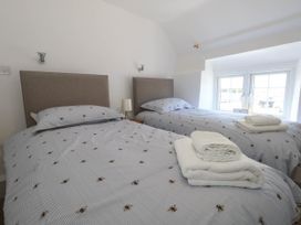 A bedroom with two beds and a window at Greenwich Cottage in Burton Bradstock