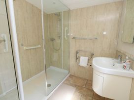 A bathroom with shower and sink at Greenwich Cottage in Burton Bradstock