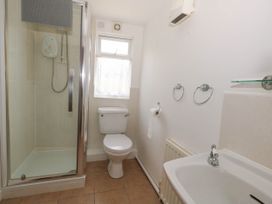 A bathroom with a shower, toilet, and sink at Greenwich Cottage in Burton Bradstock