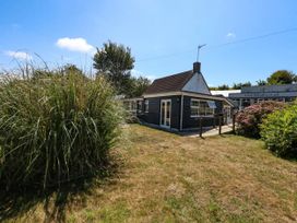 A house with surrounding grass and plants at Greenwich Cottage in Burton Bradstock