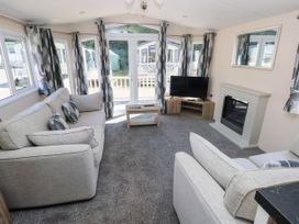 A living room with a sofa and television at Number 19 in Ferryside