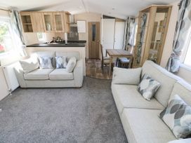 A living room with a sofa, table, and chairs at Number 19 in Ferryside