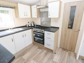 A kitchen with stove and sink at Number 19 Ferryside
