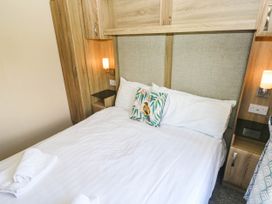 A bedroom with a bed and bedside table at Number 19 Ferryside