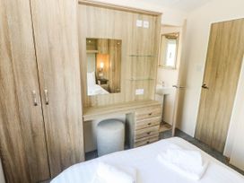 A bedroom with a wardrobe and a vanity unit at Number 19 Ferryside