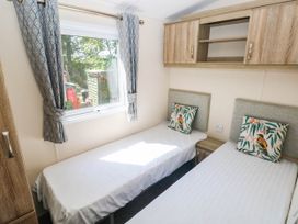 A bedroom with two beds and a window at Number 19 Ferryside
