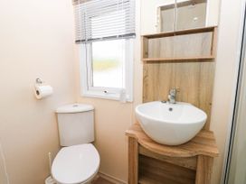 A bathroom with a toilet and sink at Number 19 in Ferryside