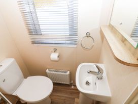 A bathroom with a toilet and sink at Number 19 in Ferryside