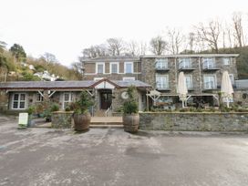 An exterior view of a stone building with umbrellas at Number 19 in Ferryside