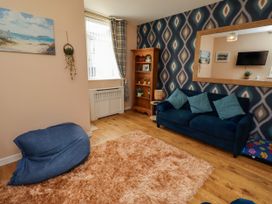 A living room with a sofa and a shelf at The Old Bank House in Red Row near Amble