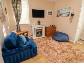 A living room with a sofa and television at The Old Bank House Red Row near Amble