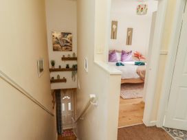 A hallway with a staircase and a door leading to a bedroom at The Old Bank House Red Row near Amble